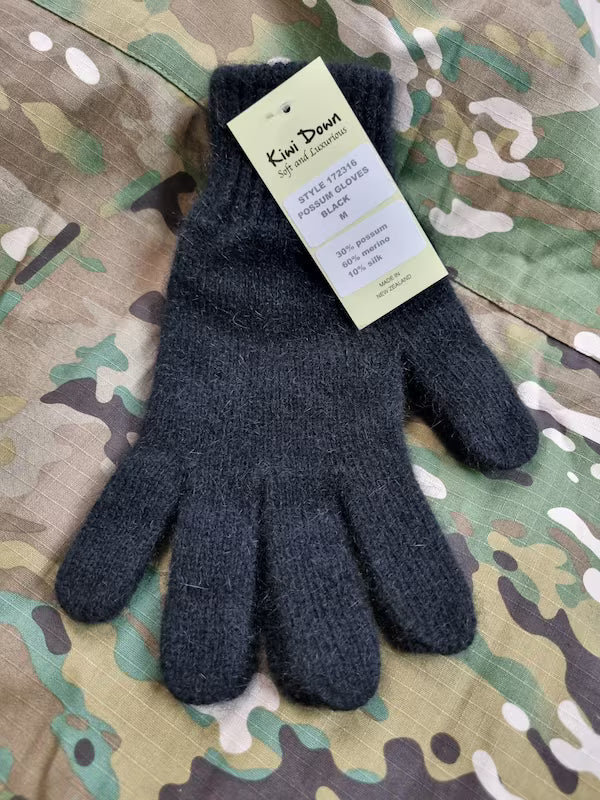 Dark gray glove with a tag on a camouflage background