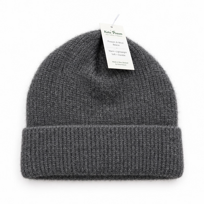 Gray knit beanie with a tag on a gray background