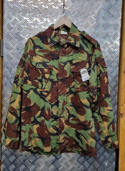 Camouflage jacket on a hanger against a metallic background