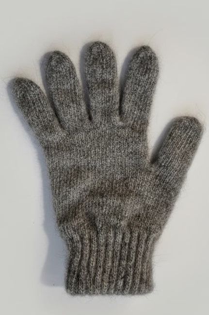 Gray knitted glove on a light gray background
