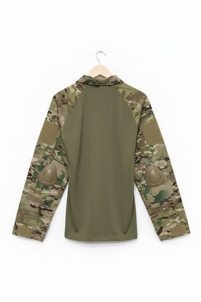 A long-sleeve tactical combat shirt shown from the back, featuring an olive green body and multicam camouflage sleeves with integrated elbow pads, hanging on a wooden hanger against a white background.