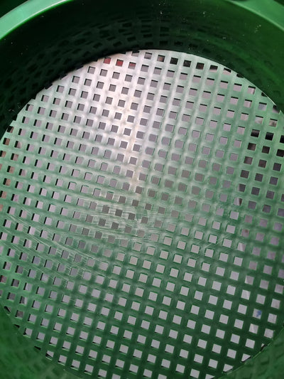 Close-up of a green plastic basket with a grid pattern