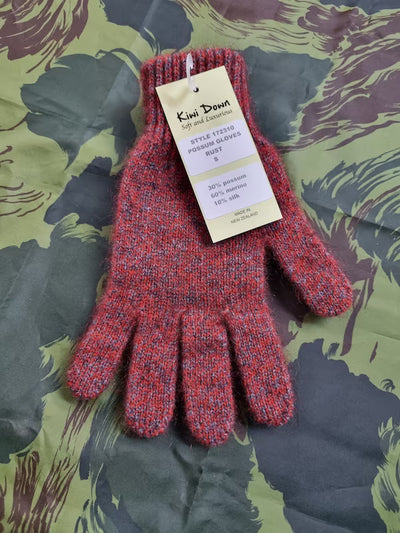 Red knitted gloves with a tag on a patterned fabric background