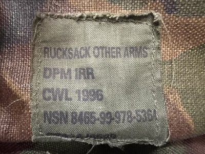 Fabric tag on a camouflage-patterned background with text and numbers.