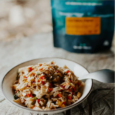 Pasta dish in a bowl with a package in the background