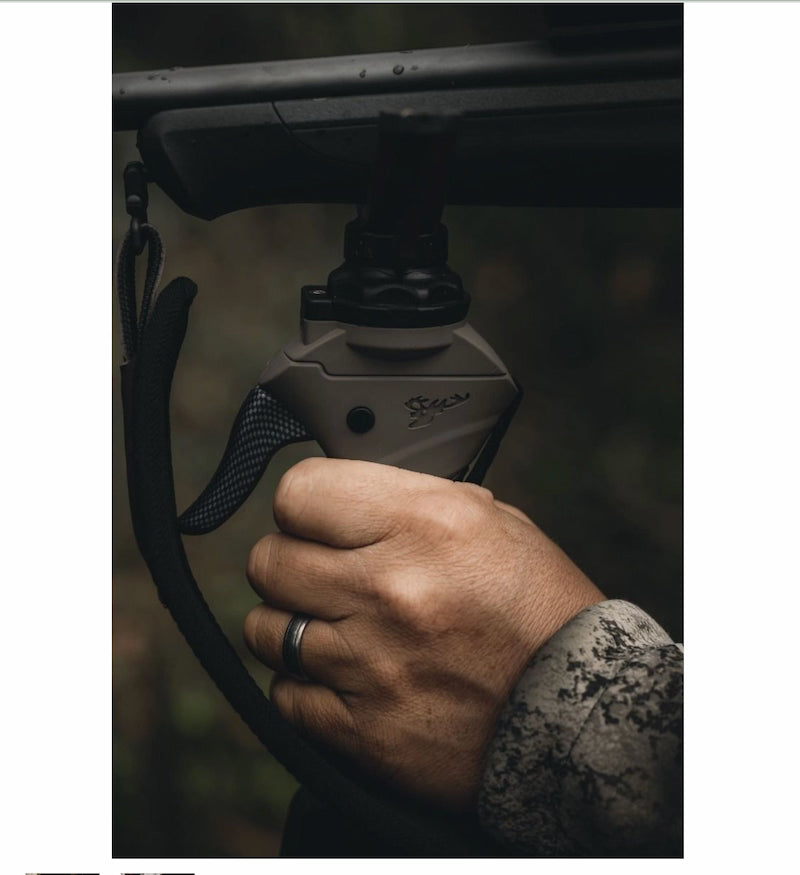 Hand holding a bow with a focus on the archery nocking point against a dark background