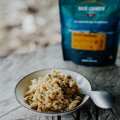 bowl of pasta with a backpack in the background