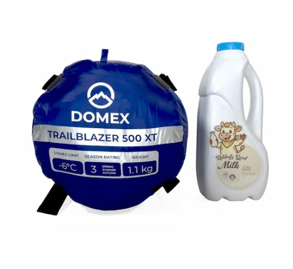 Blue Domex sleeping bag and white milk carton on a white background