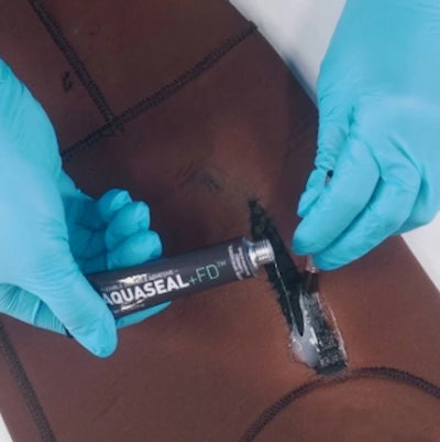Person applying Aquaseal+FD to a leather surface with blue gloves.