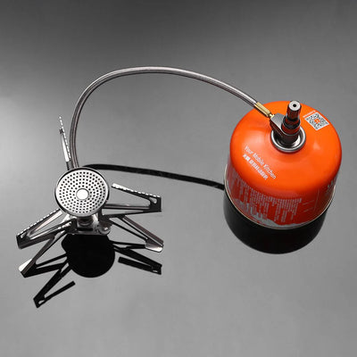 Portable camping stove with an orange fuel canister on a gray background