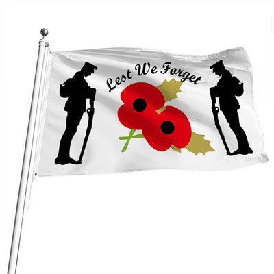A flag with a white background featuring silhouettes of soldiers and a large poppy in the center with the text 'LEST WE FORGET' across the top.