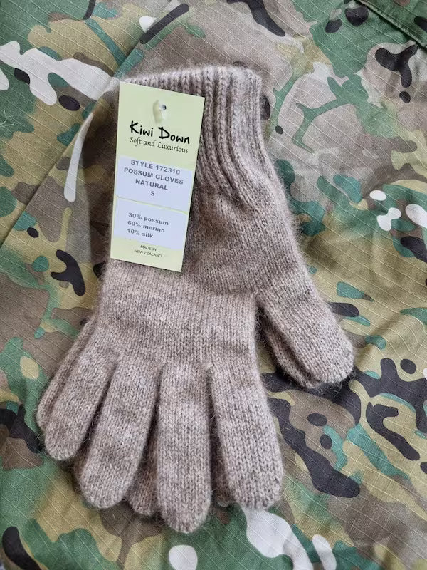 Pair of brown gloves with a tag on a camouflage background