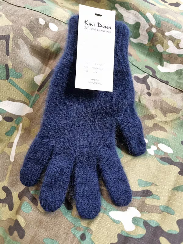 Blue knitted glove with a Kini Dana tag on a camouflage background