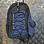 Blue and black backpack on a metallic diamond plate background