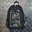 Camouflage backpack on a metallic surface