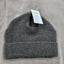 Gray knit beanie with a tag on a gray background