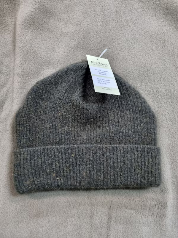 Gray knit beanie with a tag on a gray background