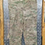 Camouflage pants on a hanger against a metallic background