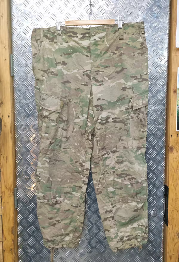 Camouflage pants on a hanger against a metallic background