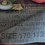 Fabric tag on a military-style jacket with size and measurement details.