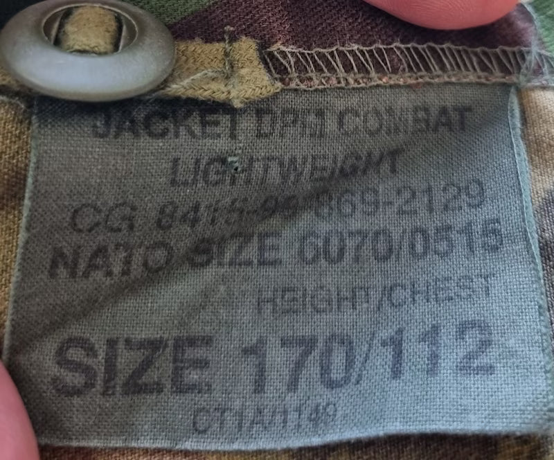 Fabric tag on a military-style jacket with size and measurement details.