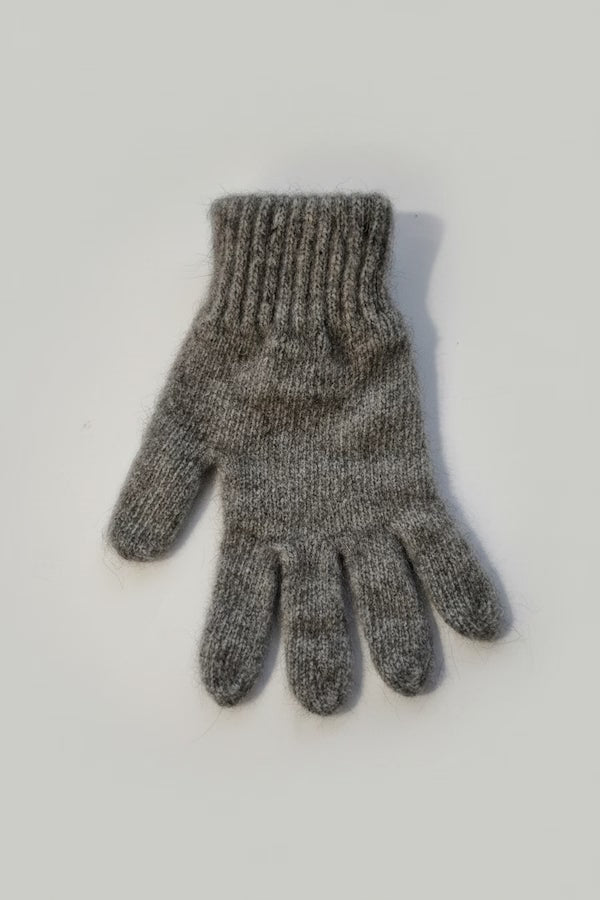 Gray knitted glove on a light gray background