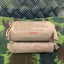 Two bandage rolls with text on a camouflage-patterned surface