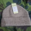 Gray knit beanie with a tag on a green camouflage background