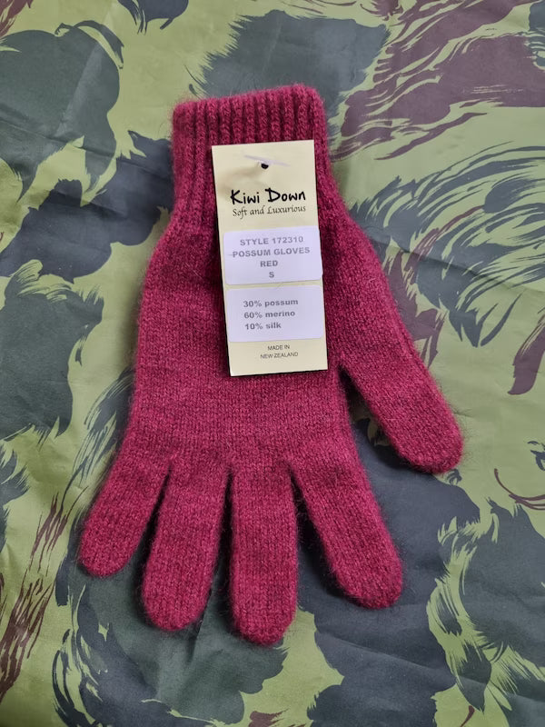 Red glove with a label on a patterned fabric background