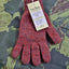 Red knitted gloves with a tag on a patterned fabric background