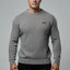 Man wearing a gray sweater with a small logo on a gray background