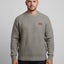 Man wearing a gray sweater with a small logo on a light gray background