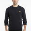Man wearing a dark blue sweater with a small logo on a white background