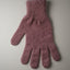 Knitted pink glove on a light gray background
