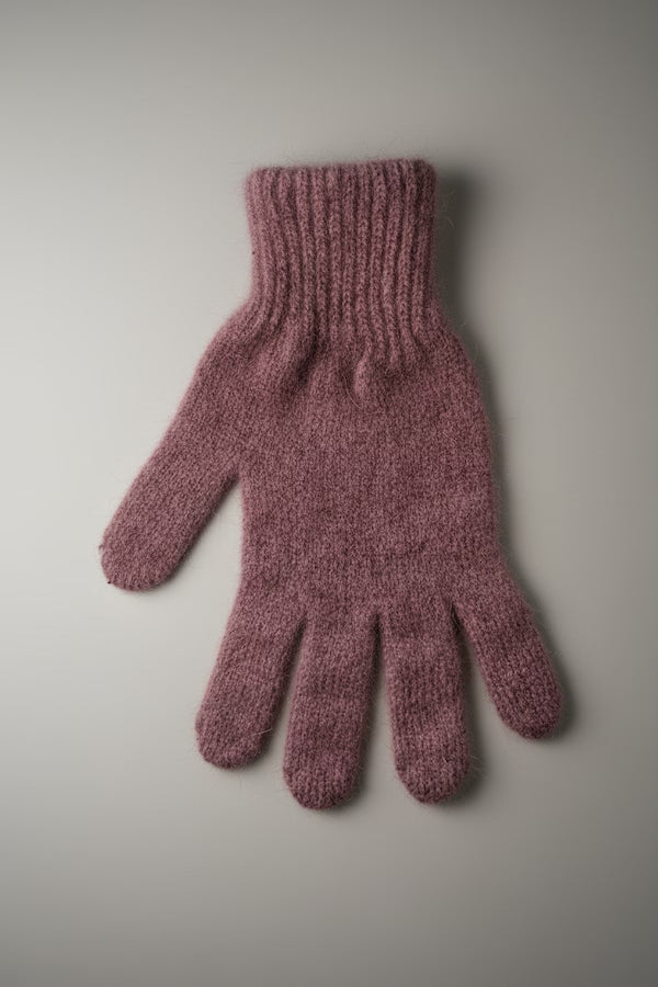 Knitted pink glove on a light gray background