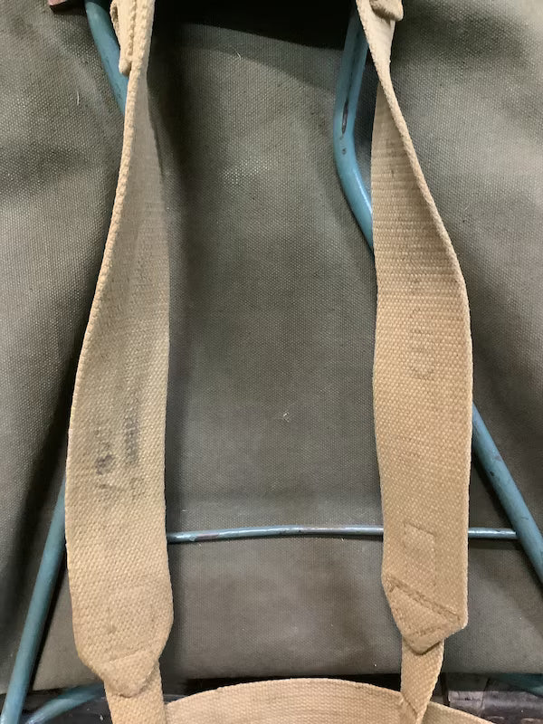 Brown leather strap on a gray bag with blue handle