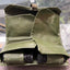 Green tactical magazine pouch with black cylindrical objects on a reflective surface
