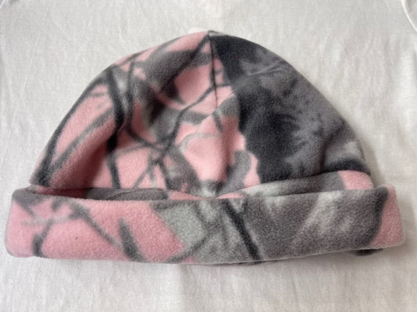 Pink and gray patterned fleece blanket on a white surface