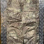 Camouflage military-style pants on a textured metal surface