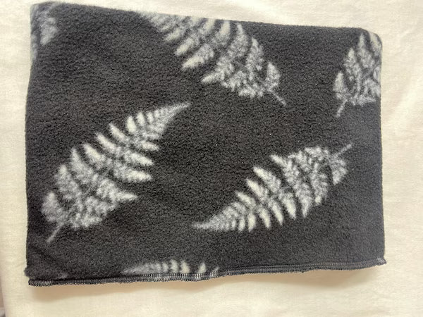 Folded towel with fern leaf pattern on a light background