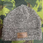 Knitted beanie with a leather patch on a green camouflage background