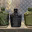 Three military-style water bottles on a metallic surface with a checkered background