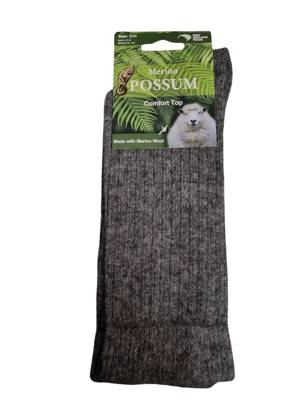 Dark gray sock with a green label featuring a polar bear and merino wool text.