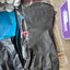 Gray gloves on a surface with packaging and other items in the background