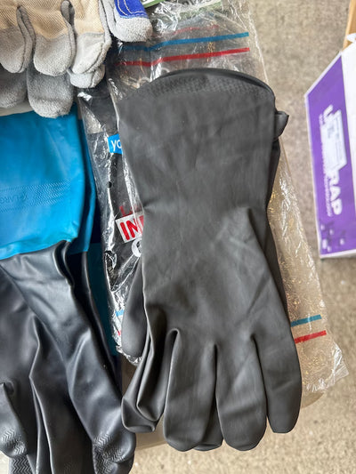 Gray gloves on a surface with packaging and other items in the background