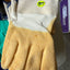 Beige glove with white cuff and blue trim on a gray surface
