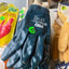 Pair of blue gloves with a brand logo on a shelf with other items.