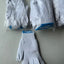 White gloves with blue accents on a gray surface