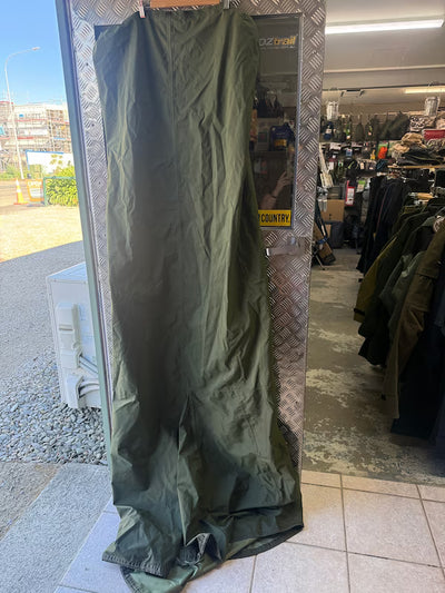 Green tarpaulin with a brand logo on a metal frame in an outdoor setting.