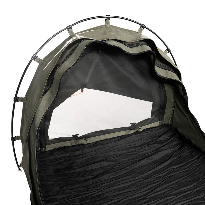 Close-up of a camping tent with a black interior and green exterior on a white background